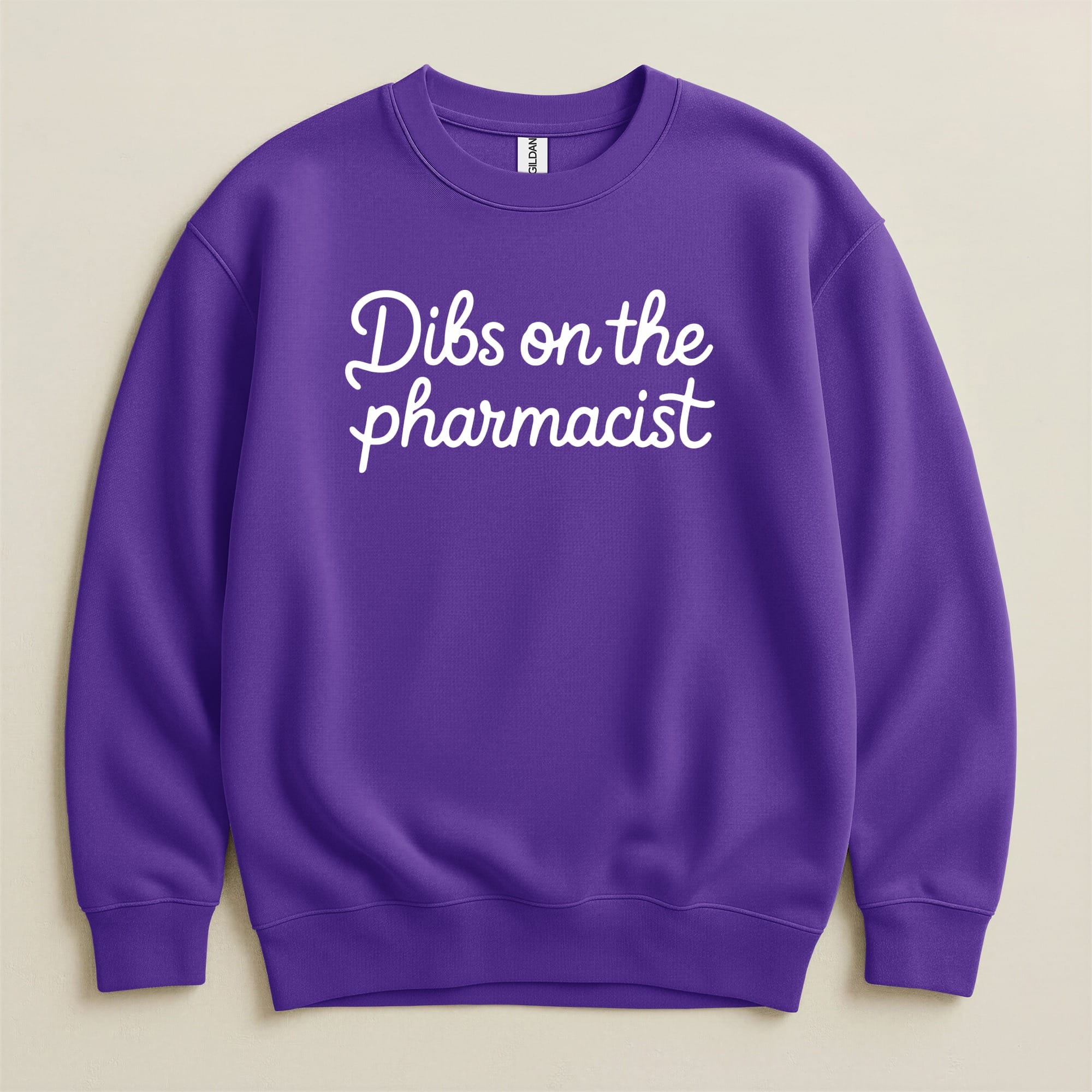 Purple Gildan sweatshirt with white text that says "Dibs on the pharmacist".