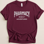 Maroon t-shirt with "Pharmacy Adventures" text in white block letters.