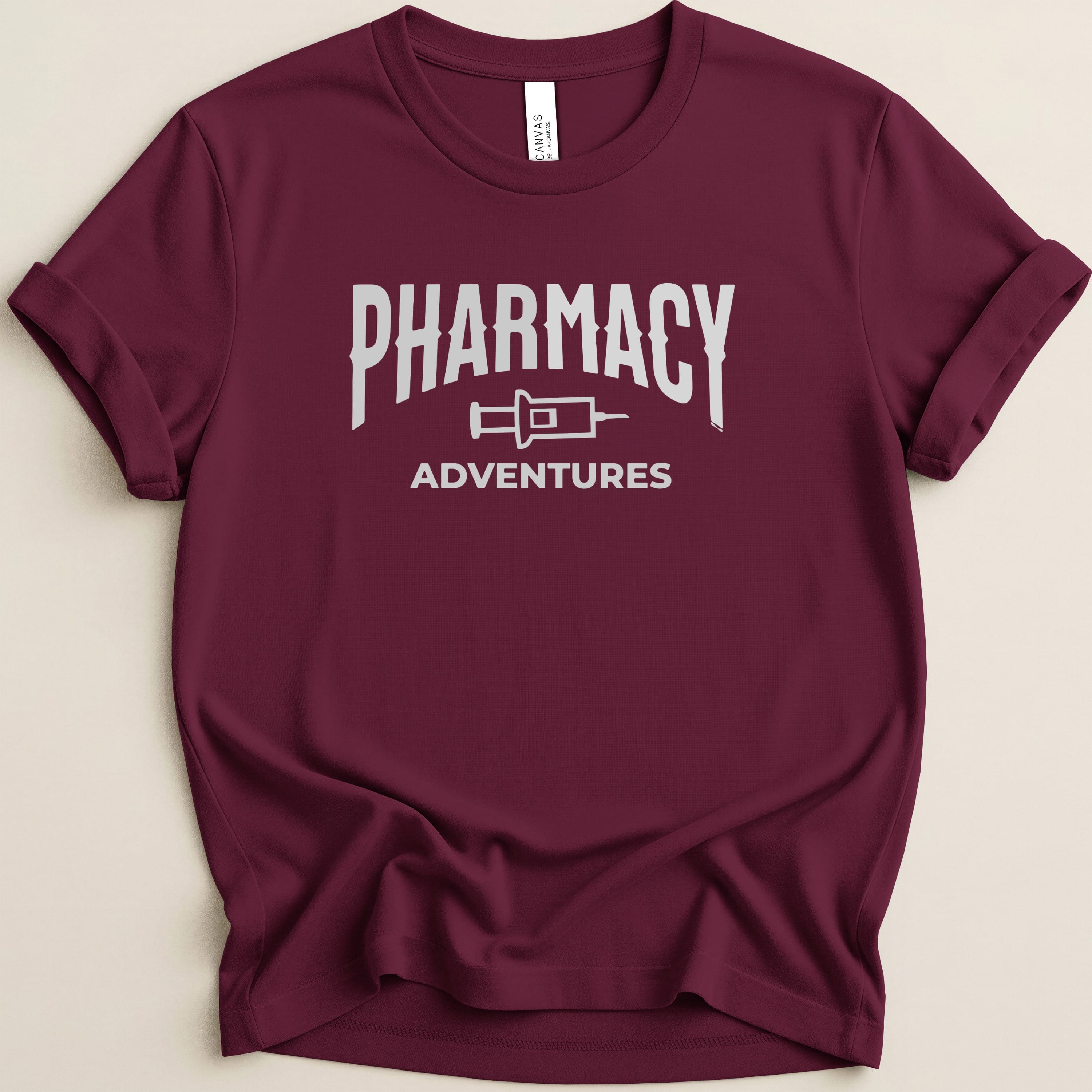 Maroon t-shirt with "Pharmacy Adventures" text in white block letters.