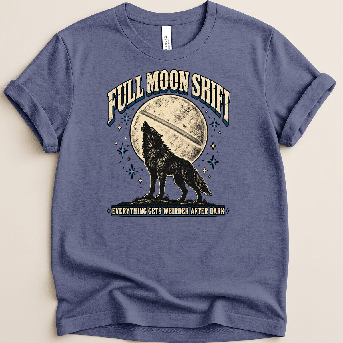 Blue t-shirt with a graphic of a wolf howling at a full moon. Text reads "Full Moon Shift" and "Everything Gets Weirder After Dark".
