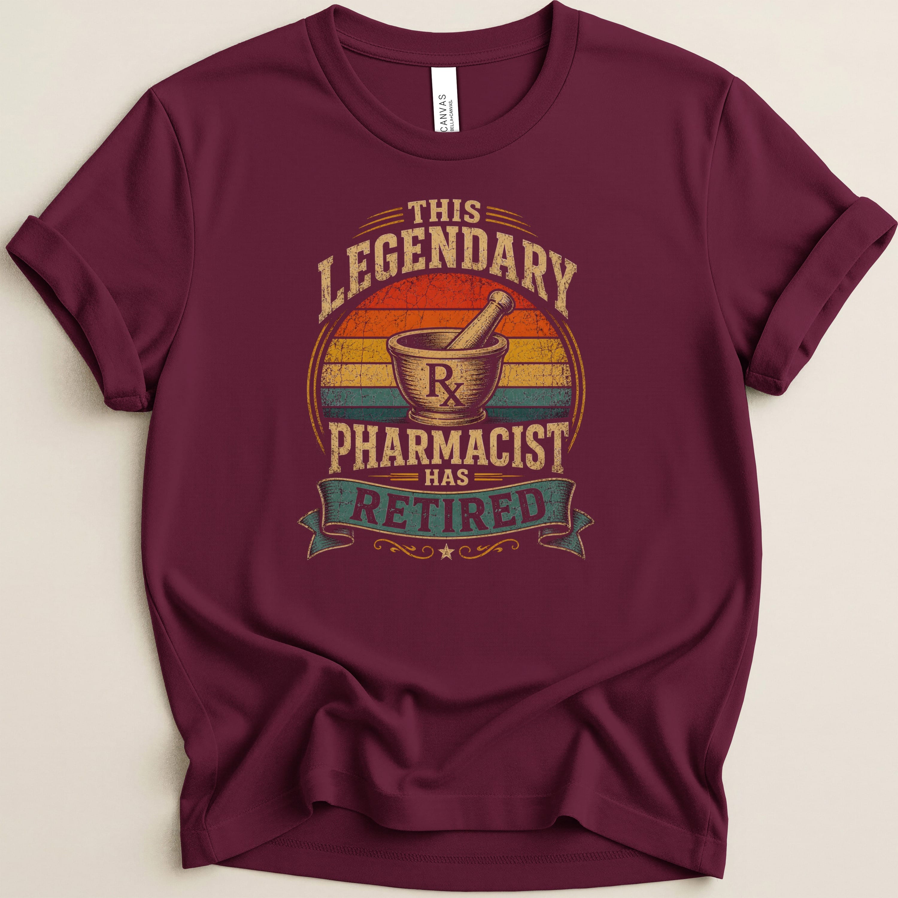Maroon t-shirt with "This legendary pharmacist has retired" text and mortar and pestle graphic.