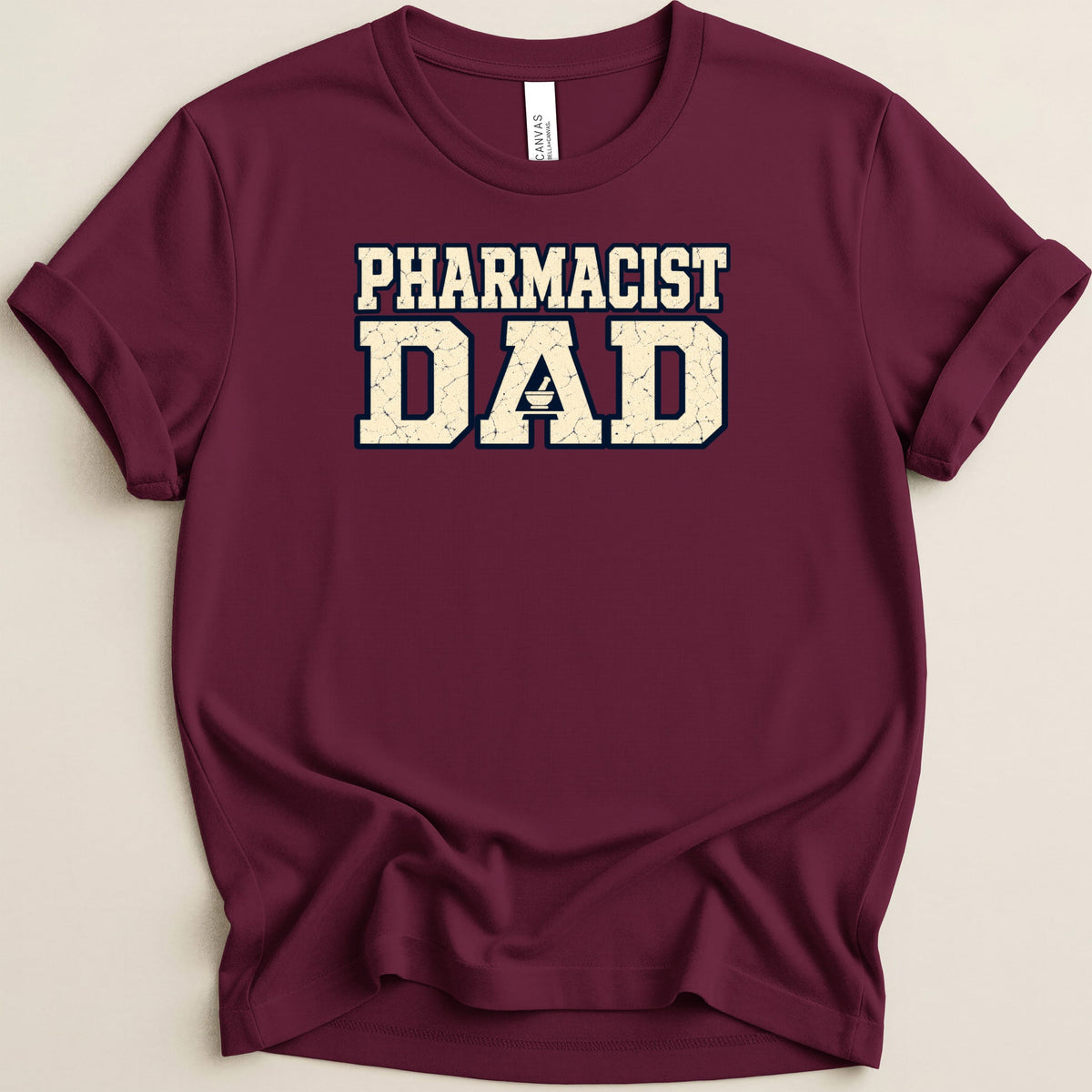 Maroon t-shirt with rolled-up sleeves featuring the distressed white text PHARMACIST DAD across the chest.
