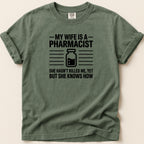 Green t-shirt with "My wife is a pharmacist" text and graphic.