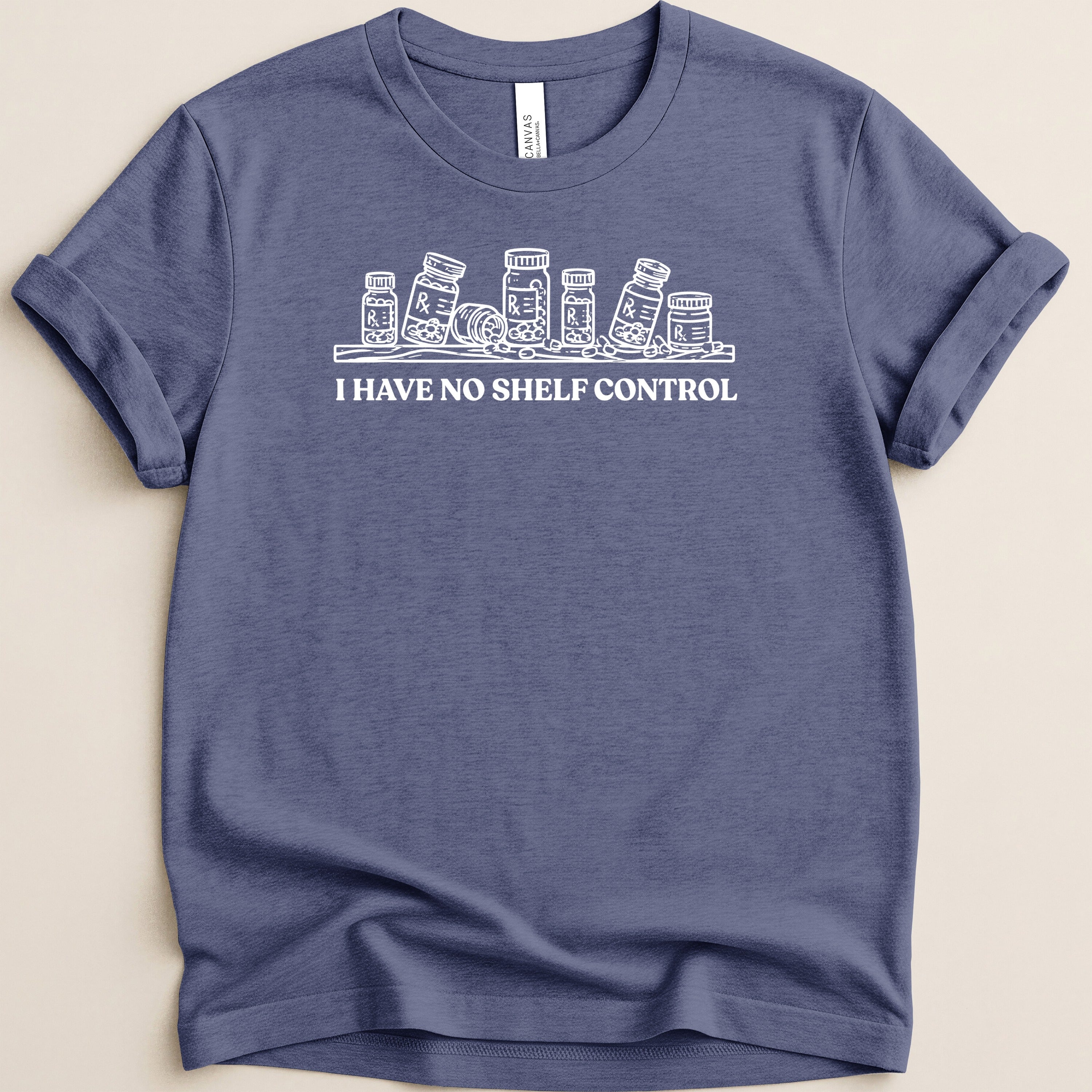 Blue t-shirt with white line drawing of pill bottles and text "I HAVE NO SHELF CONTROL".