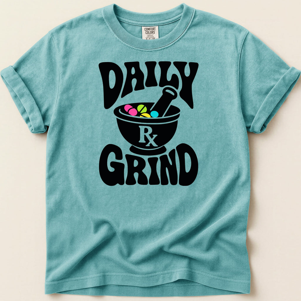 Teal t-shirt with "Daily Grind" text and mortar and pestle with pills graphic.