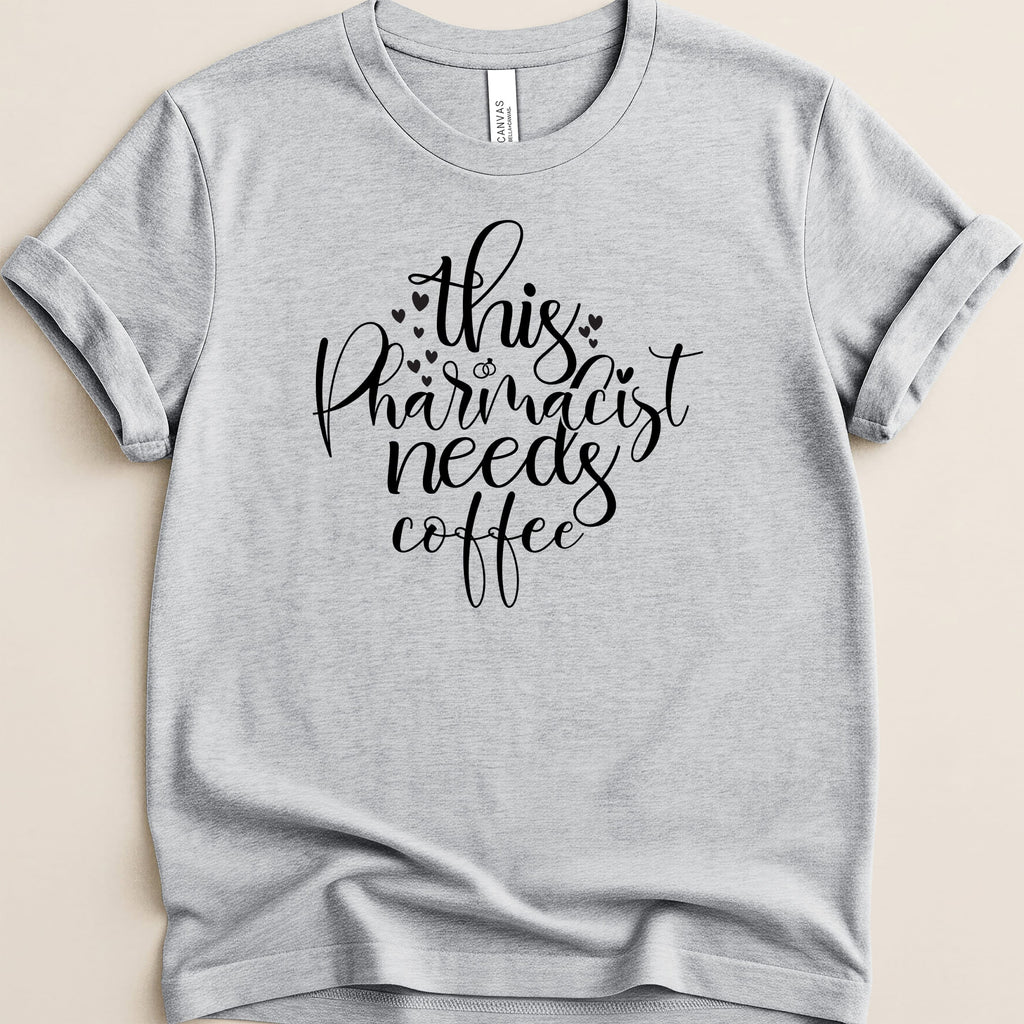 Light grey t-shirt with "this pharmacist needs coffee" text and heart details.