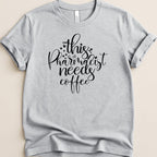 Light grey t-shirt with "this pharmacist needs coffee" text and heart details.
