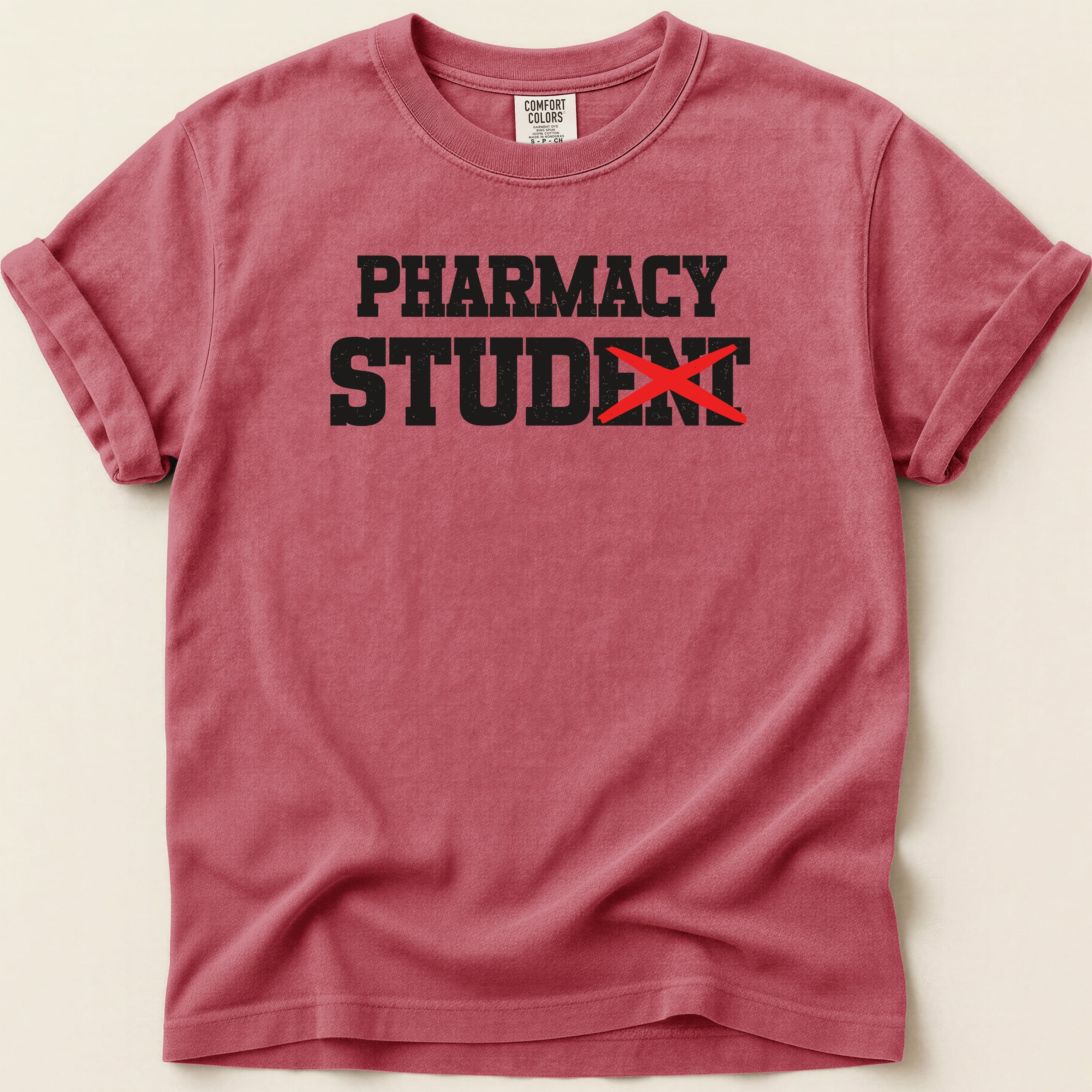 Red t-shirt with "Pharmacy Student" text, "dent" crossed out in black.