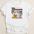 White t-shirt with cartoon cat pharmacist graphic reading "The Pharmeowcist will See you now".