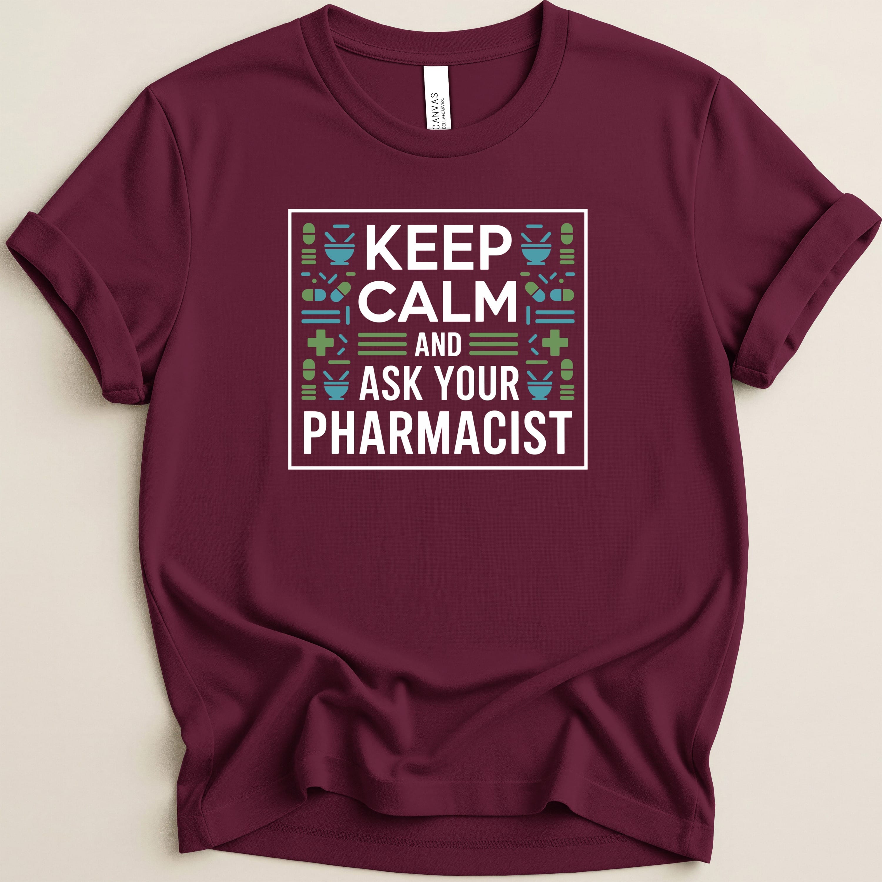 Maroon t-shirt with "Keep Calm and Ask Your Pharmacist" text and medical icons.