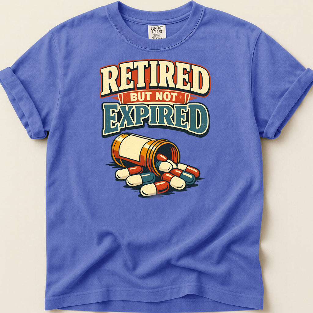 T-shirt with text "Retired But Not Expired" and spilled pill bottle.