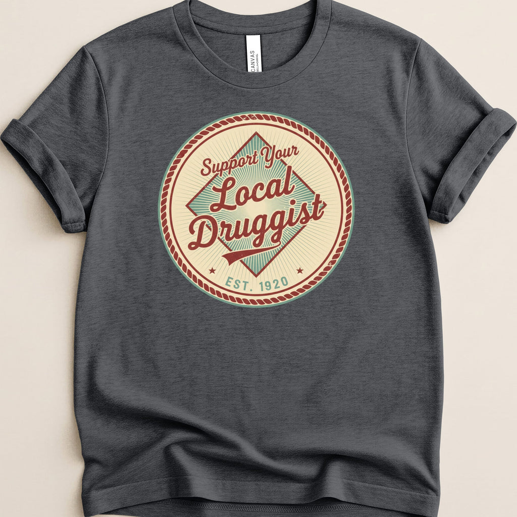 Dark t-shirt with circular "Support Your Local Druggist Est. 1920" graphic.