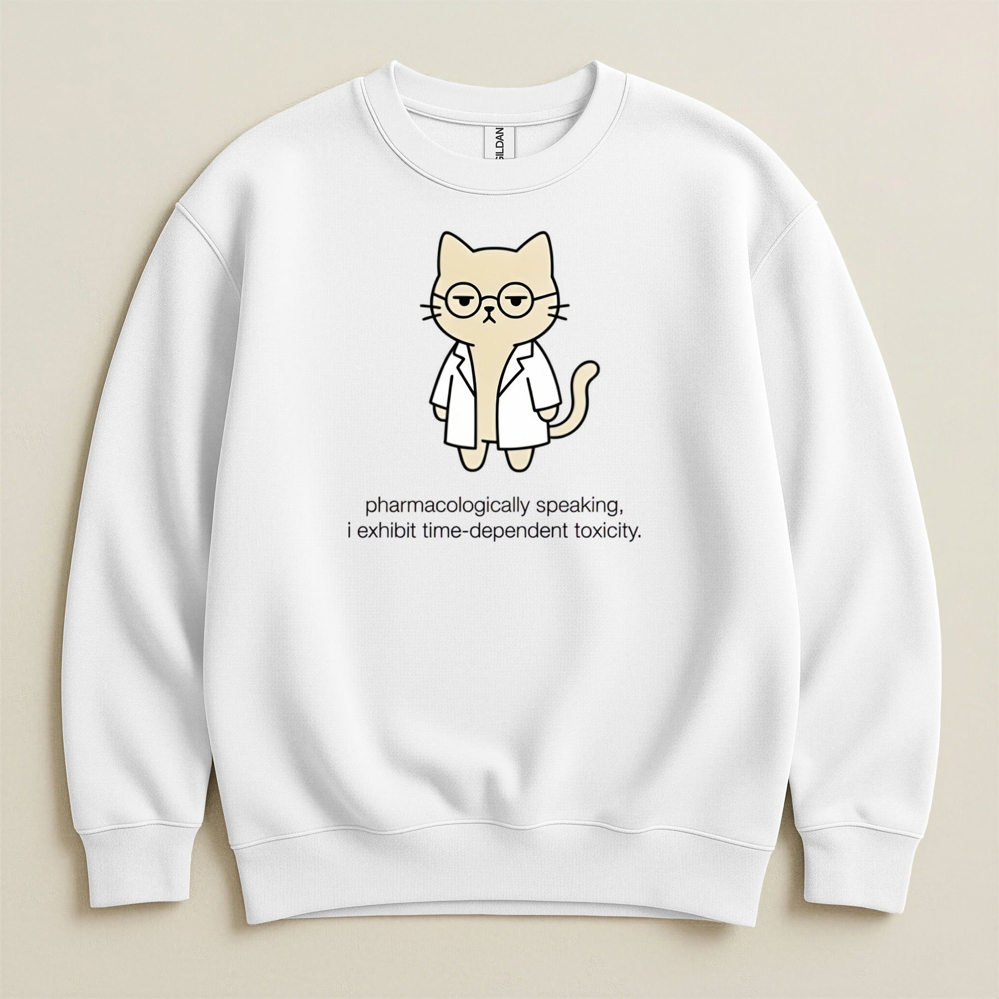 White sweatshirt with cartoon cat in lab coat and glasses, text reads "pharmacologically speaking, i exhibit time-dependent toxicity."