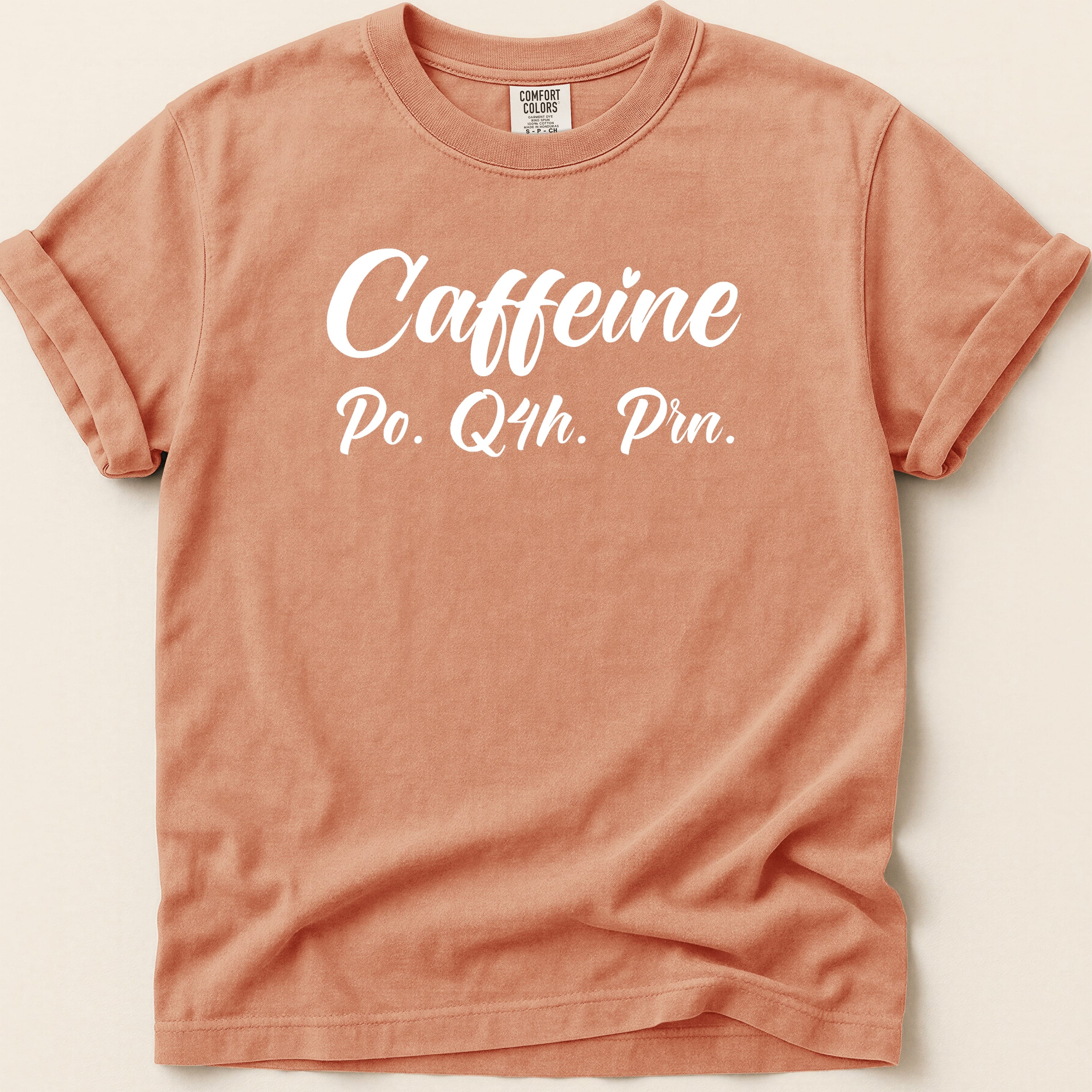 Peach t-shirt with "Caffeine Po. Q4h. Prn." text.