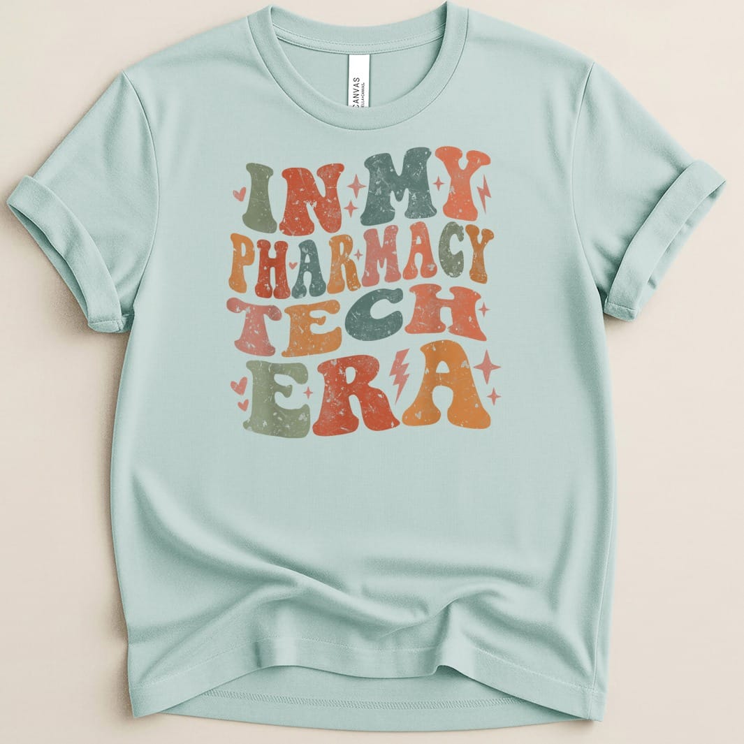 Light blue t-shirt with "IN MY PHARMACY TECH ERA" in retro, colorful text.