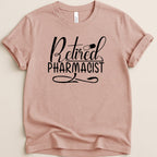 Pink t-shirt with "Retired Pharmacist" text and a pill graphic.