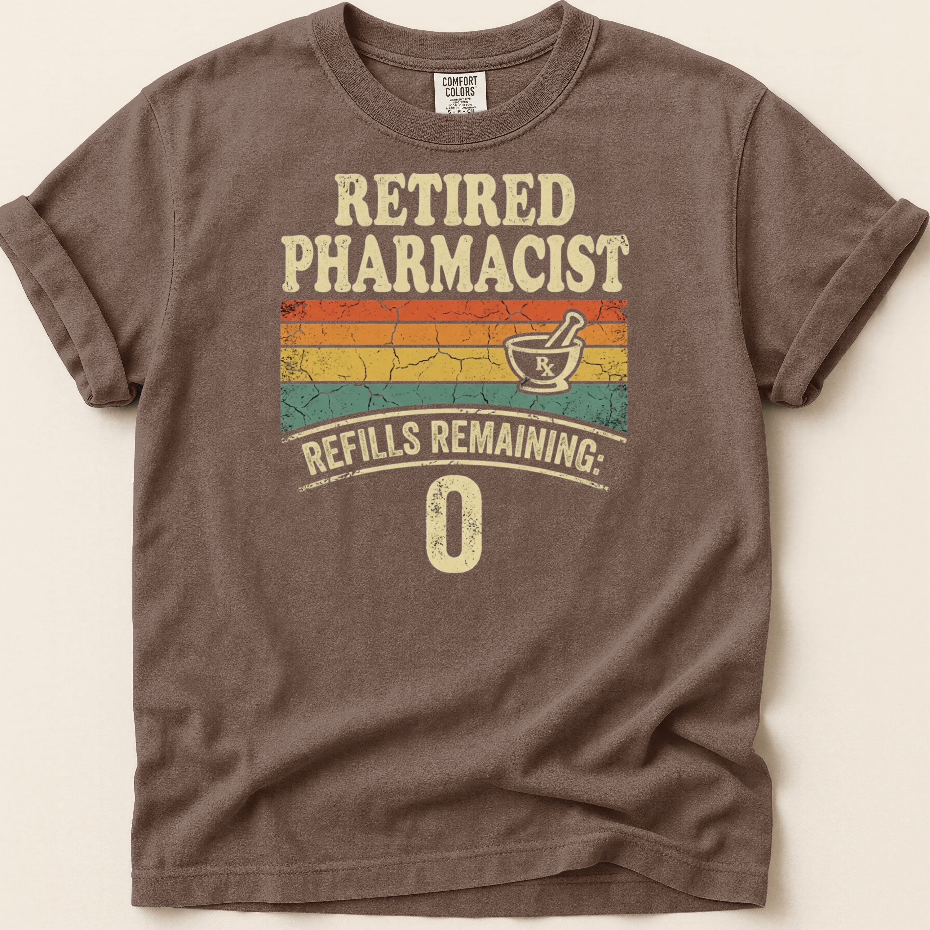 Retired Pharmacist text with refills remaining: 0, on a brown t-shirt.