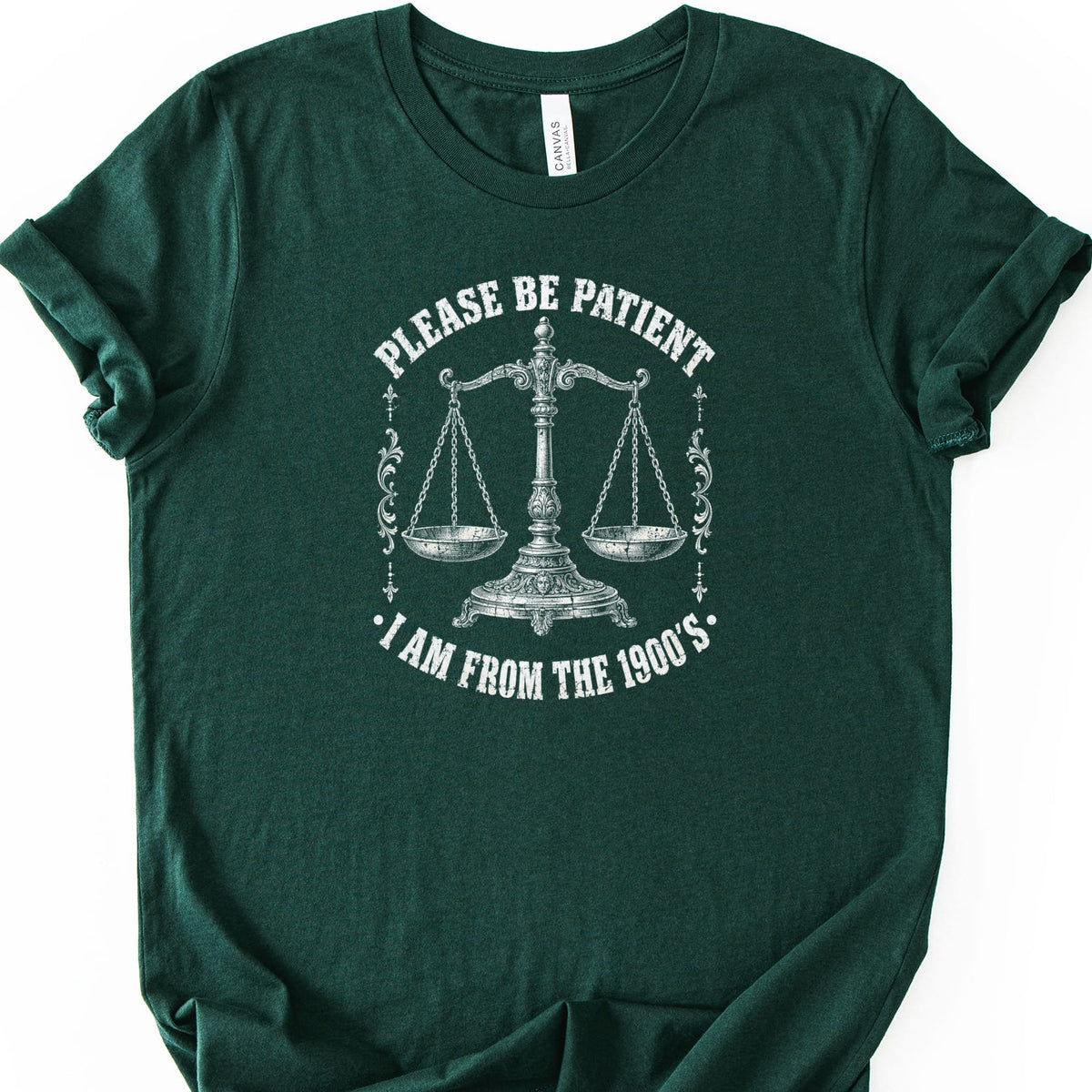 Green t-shirt with a vintage scale and text "Please be patient, I am from the 1900's".