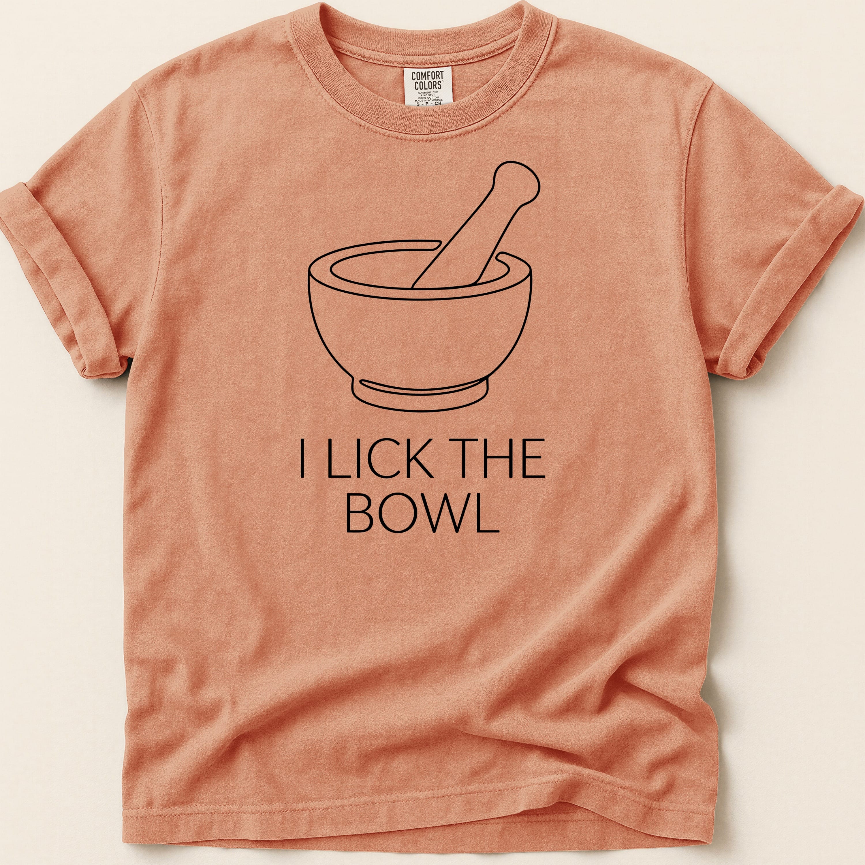Peach t-shirt with "I LICK THE BOWL" and a mortar and pestle graphic.