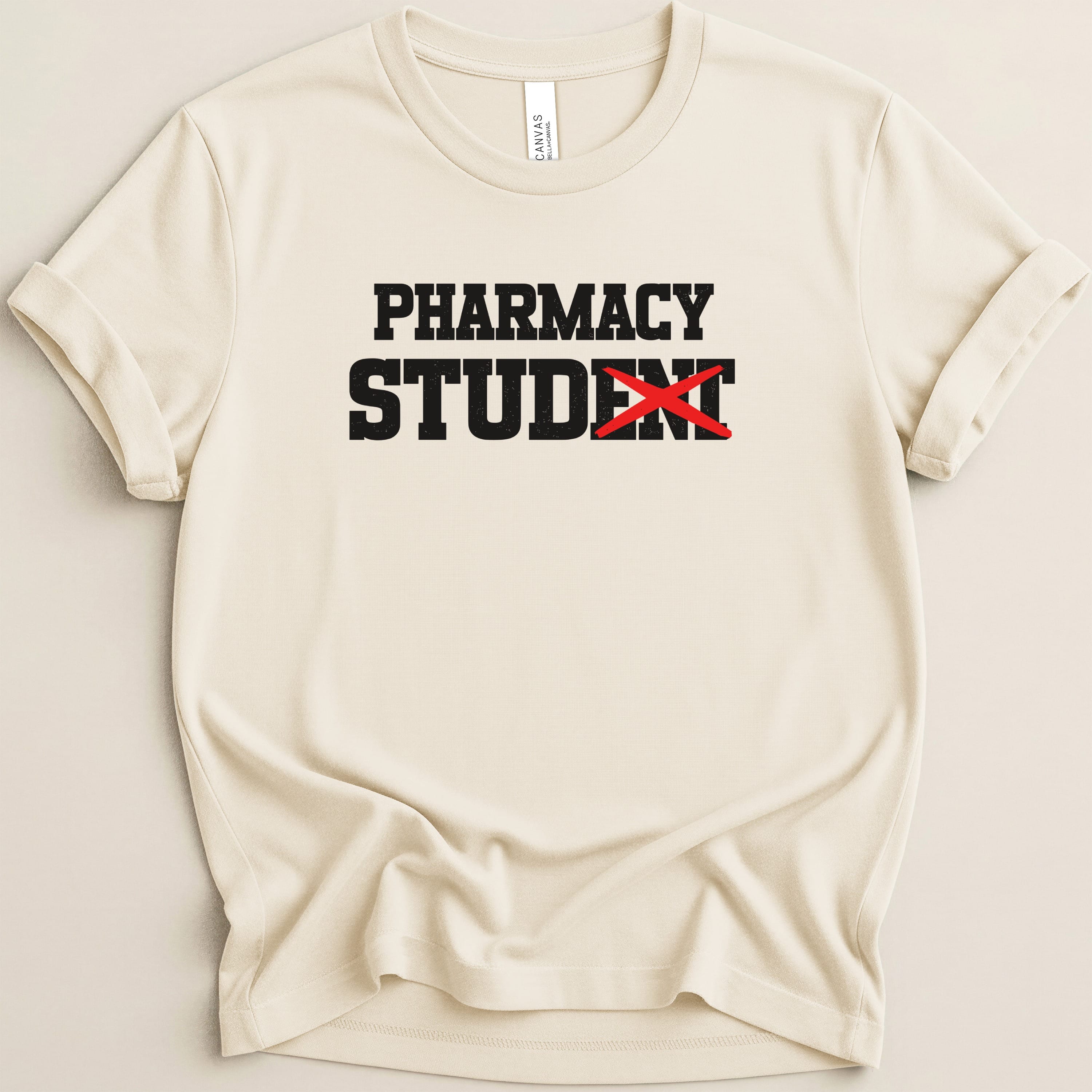 Cream t-shirt with black text "PHARMACY STUDENT" with a red X over STUDENT.