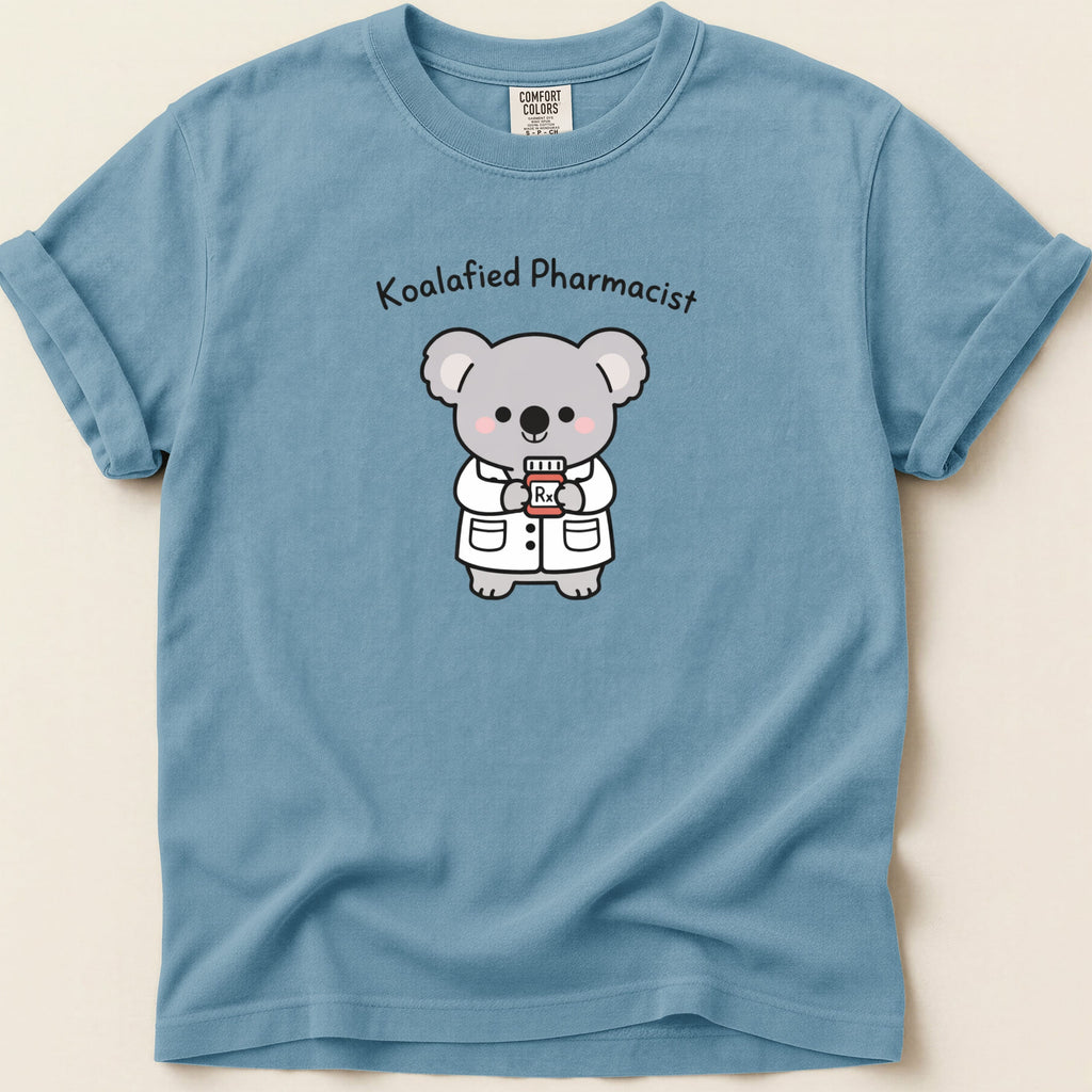 Blue t-shirt with cartoon koala in pharmacist coat holding prescription bottle.