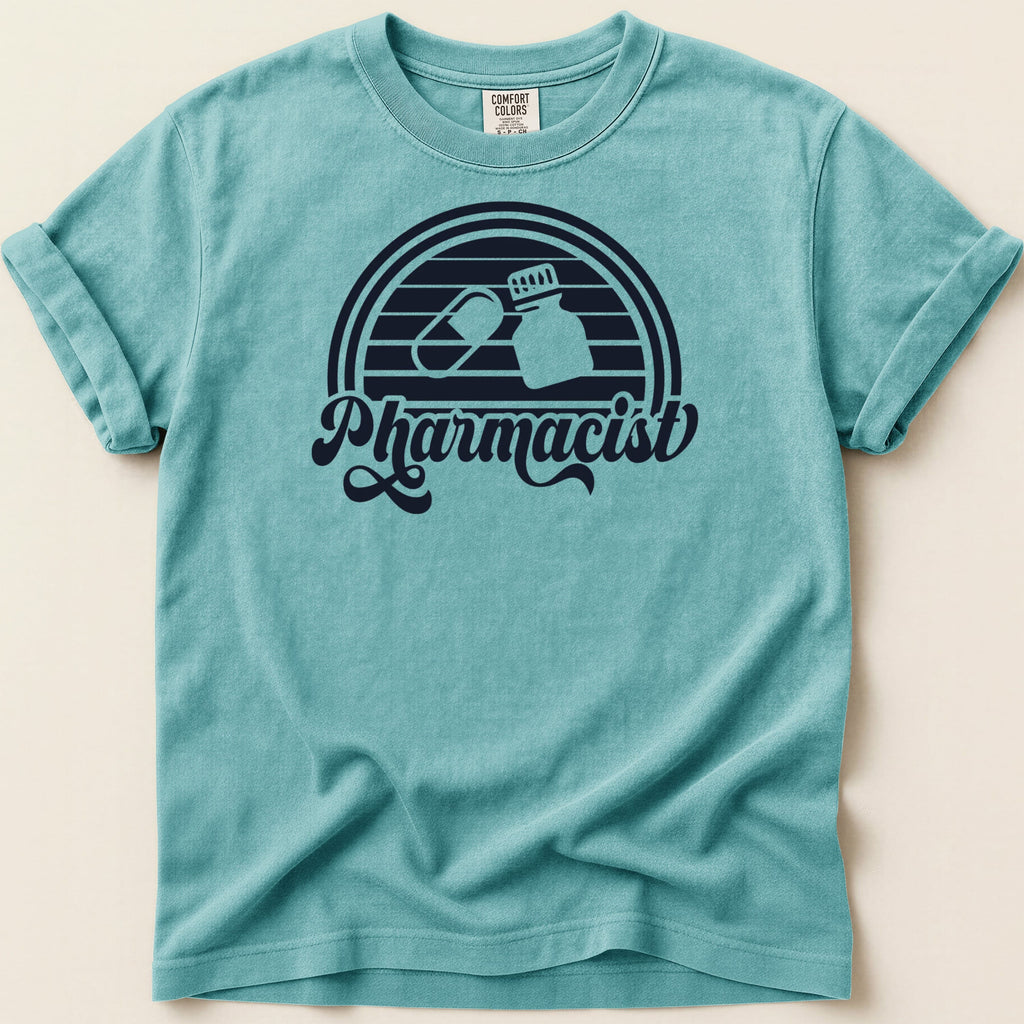 Teal t-shirt with "Pharmacist" text and pill capsule and bottle graphics.