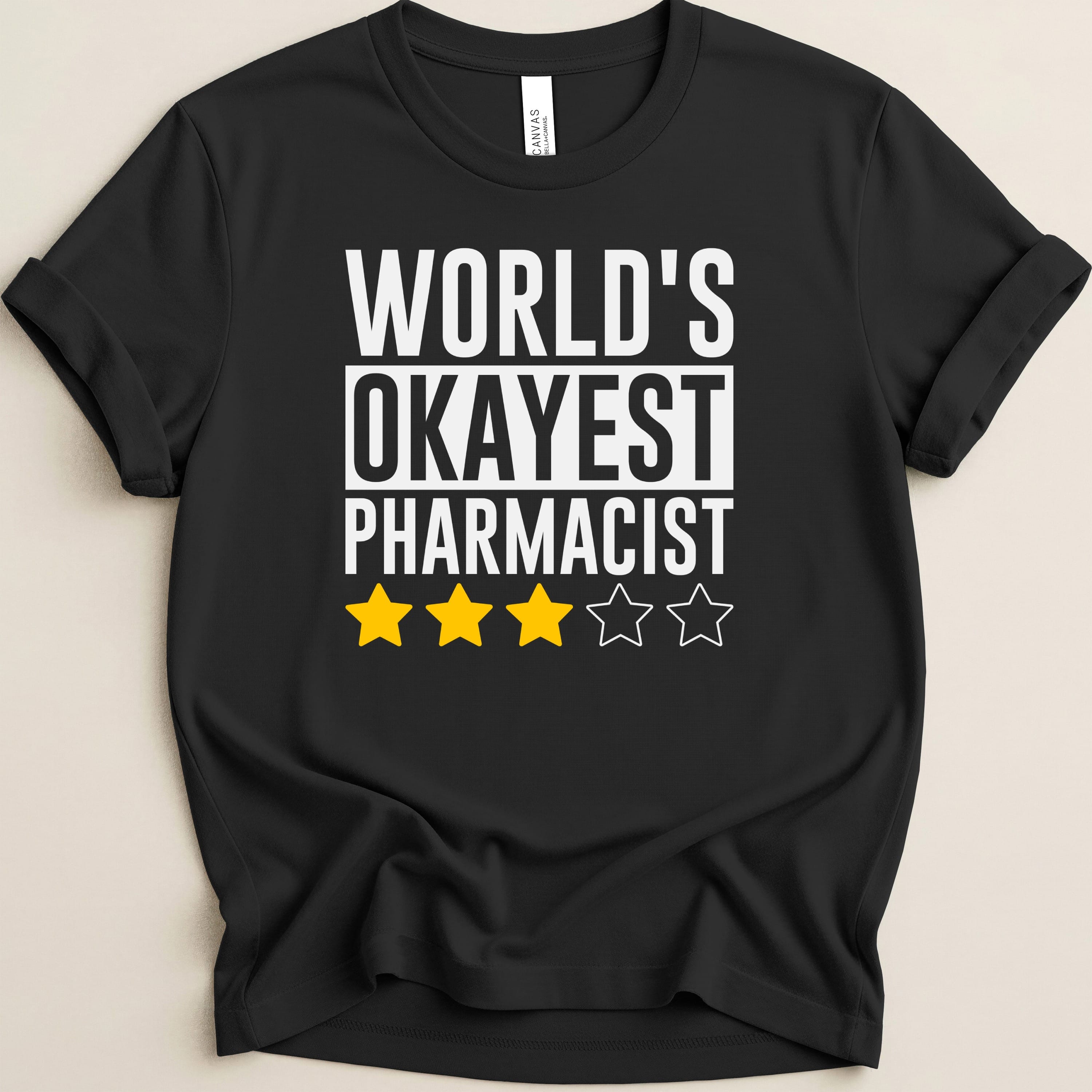 Black t-shirt with "World's Okayest Pharmacist" and three yellow stars.