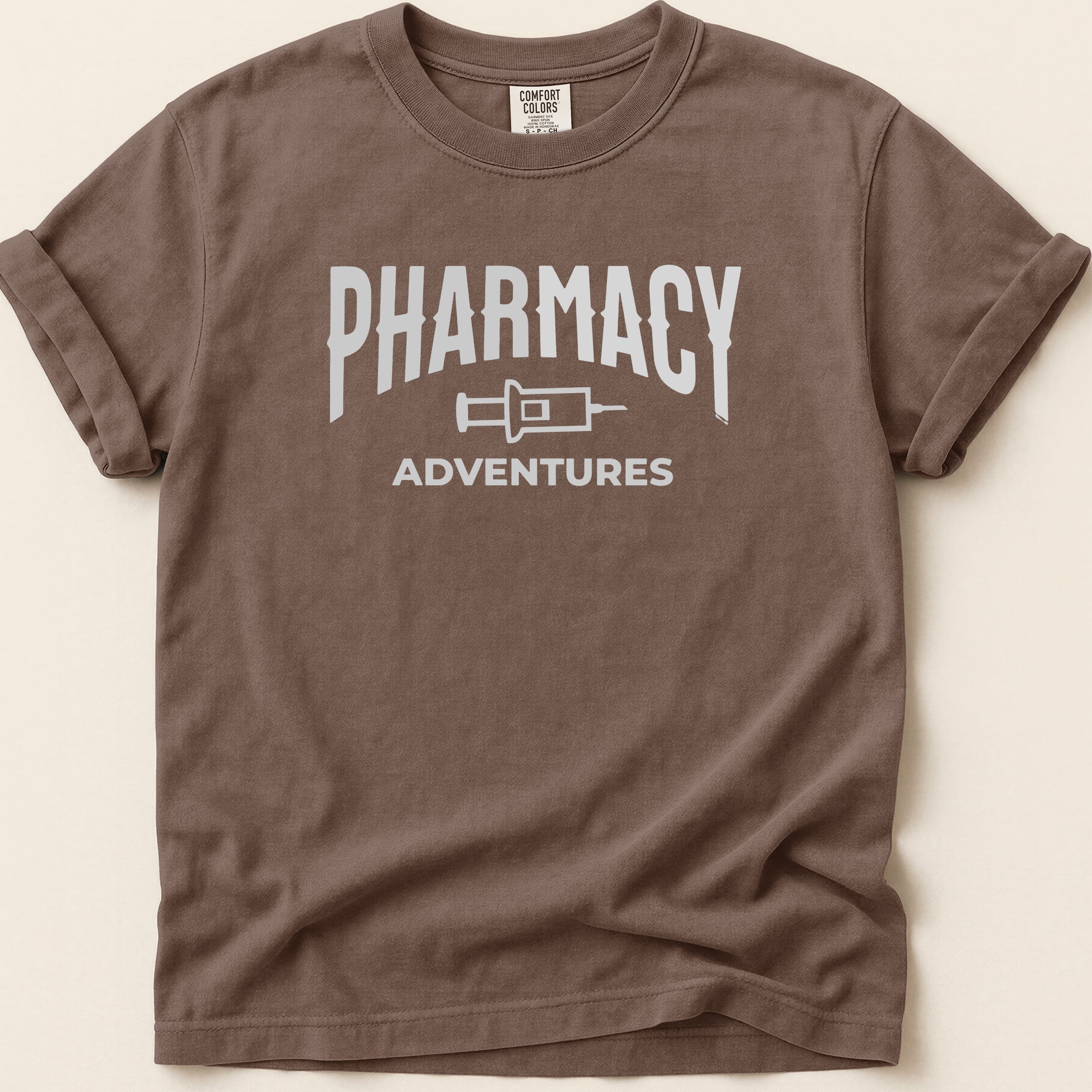 Brown t-shirt with white "Pharmacy Adventures" graphic.