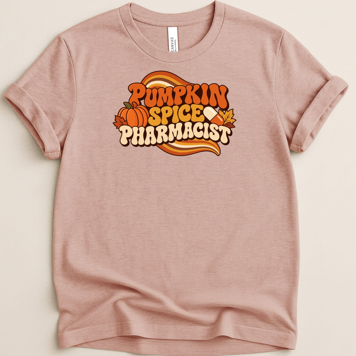 Dusty pink t-shirt with retro graphics, a small pumpkin, and the text Pumpkin Spice Pharmacist.