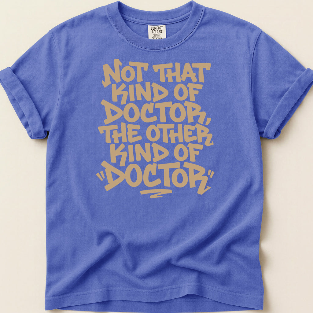 Blue t-shirt with tan text reading "Not that kind of doctor, the other kind of 'doctor'"