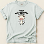 White t-shirt with cartoon cow wearing lab coat and text "Your moo-dication is ready".