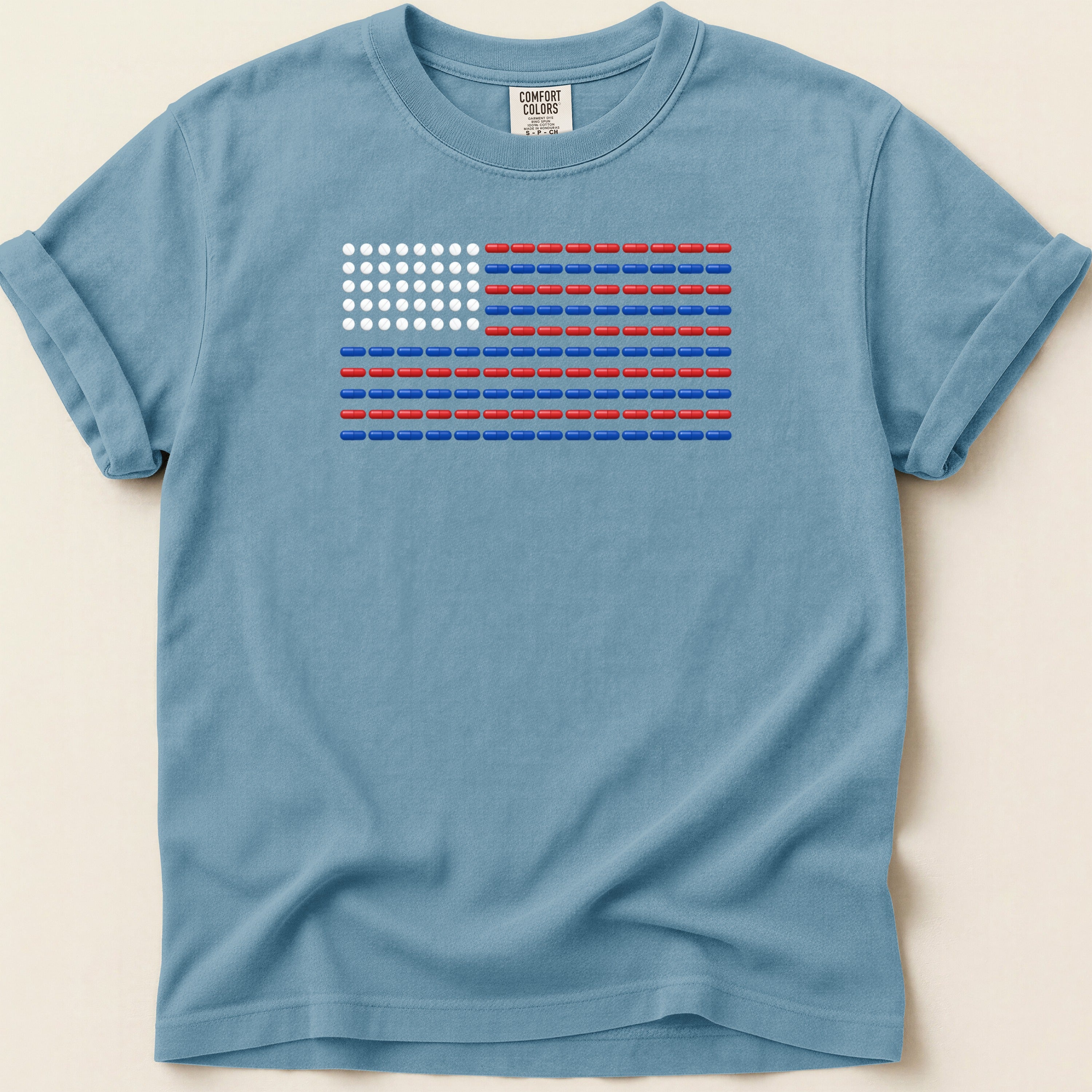 Blue t-shirt with American flag design made of red and white pills.