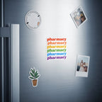 Magnets with "pharmacy" in rainbow colors on a stainless steel refrigerator.