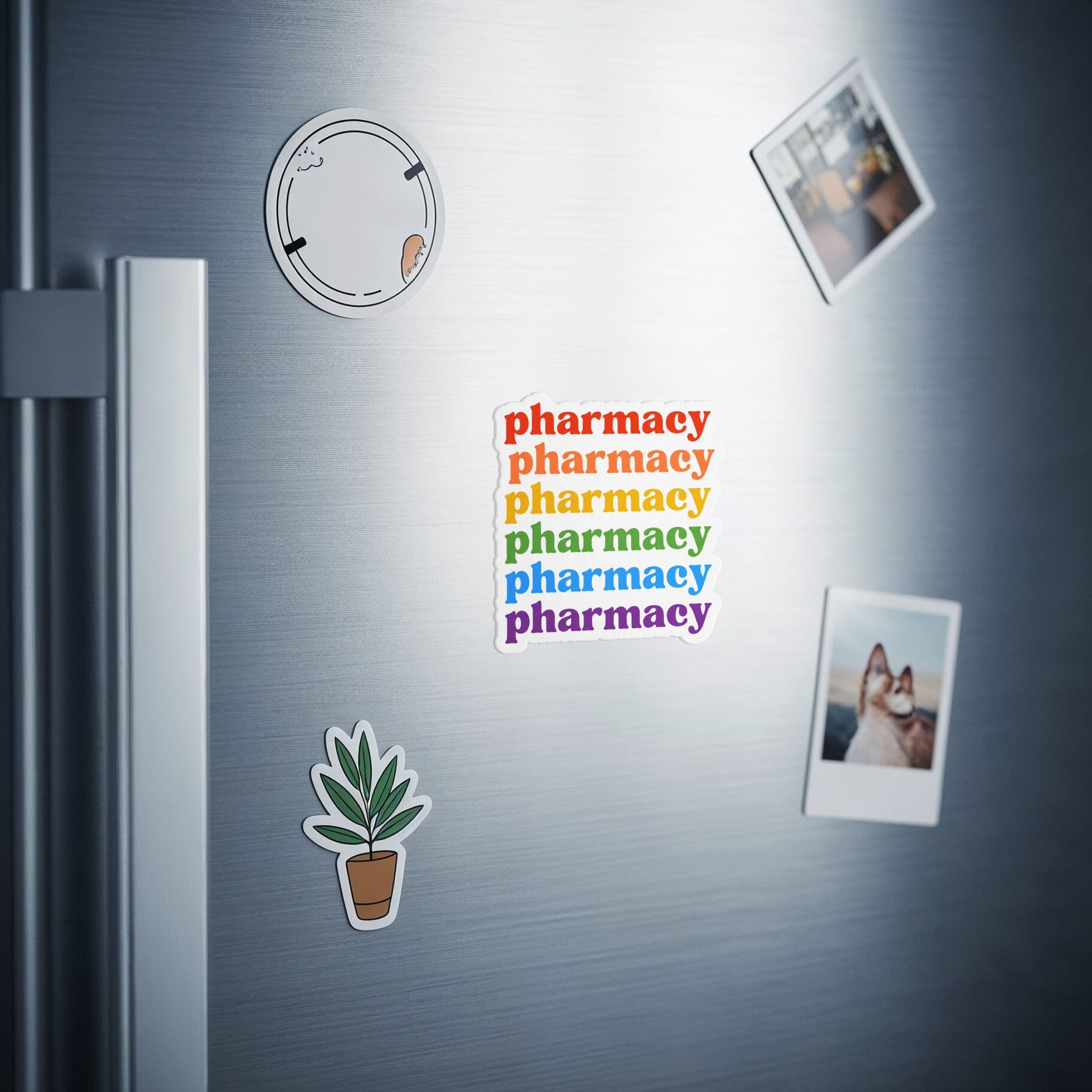 Magnets with "pharmacy" in rainbow colors on a stainless steel refrigerator.