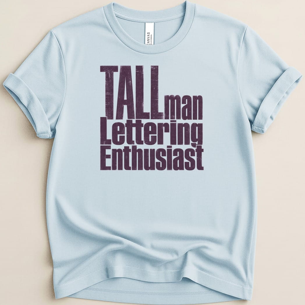 Light blue t-shirt with "TALL man Lettering Enthusiast" text in purple.