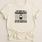 Cream t-shirt with black text: "My wife is a pharmacist. She hasn't killed me, yet but she knows how."
