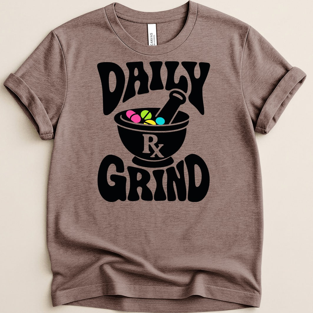 Brown t-shirt with black text "DAILY GRIND" and a mortar and pestle holding pills.