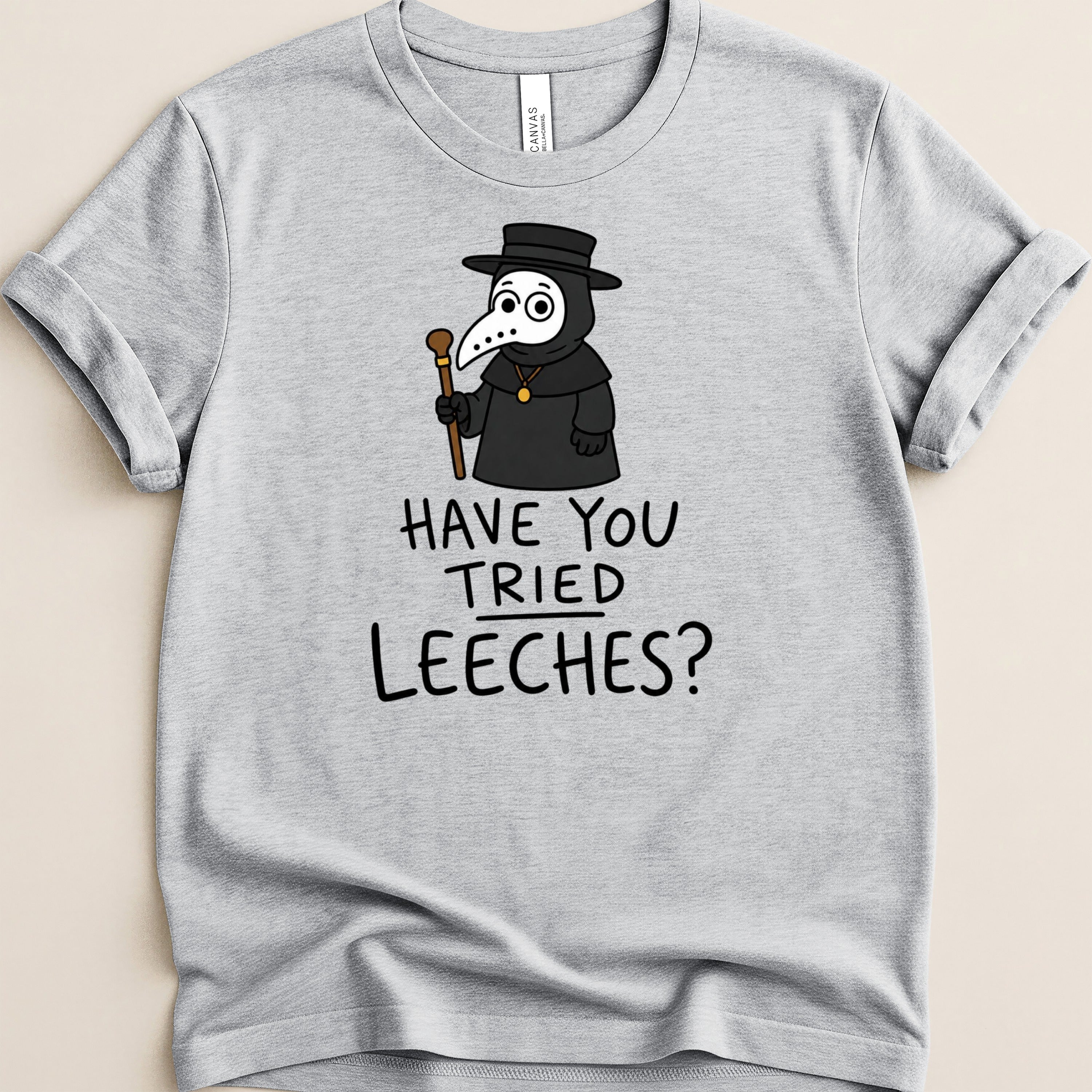 Grey t-shirt with cartoon plague doctor and text "HAVE YOU TRIED LEECHES?".