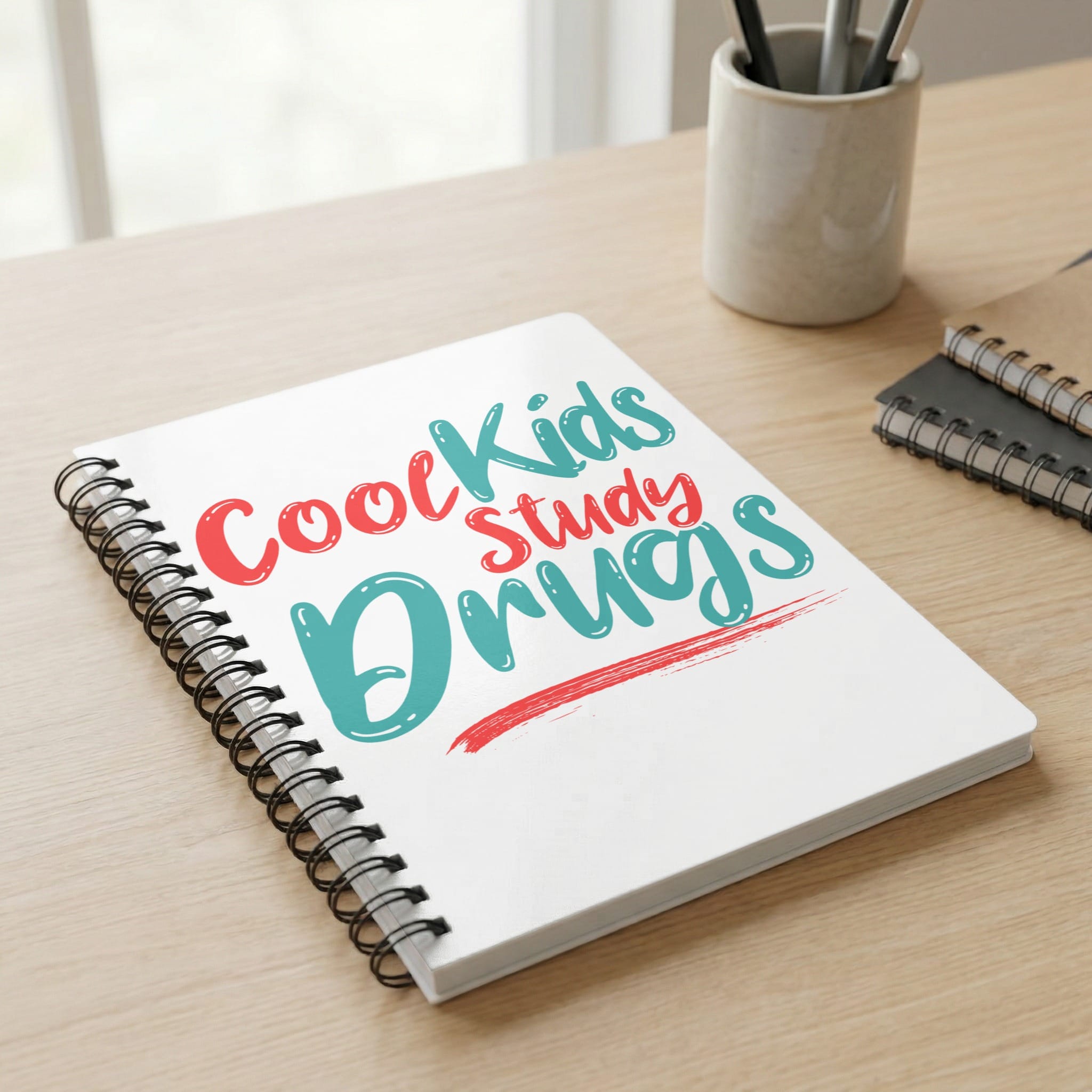 Notebook with "Cool Kids Study Drugs" text on cover.