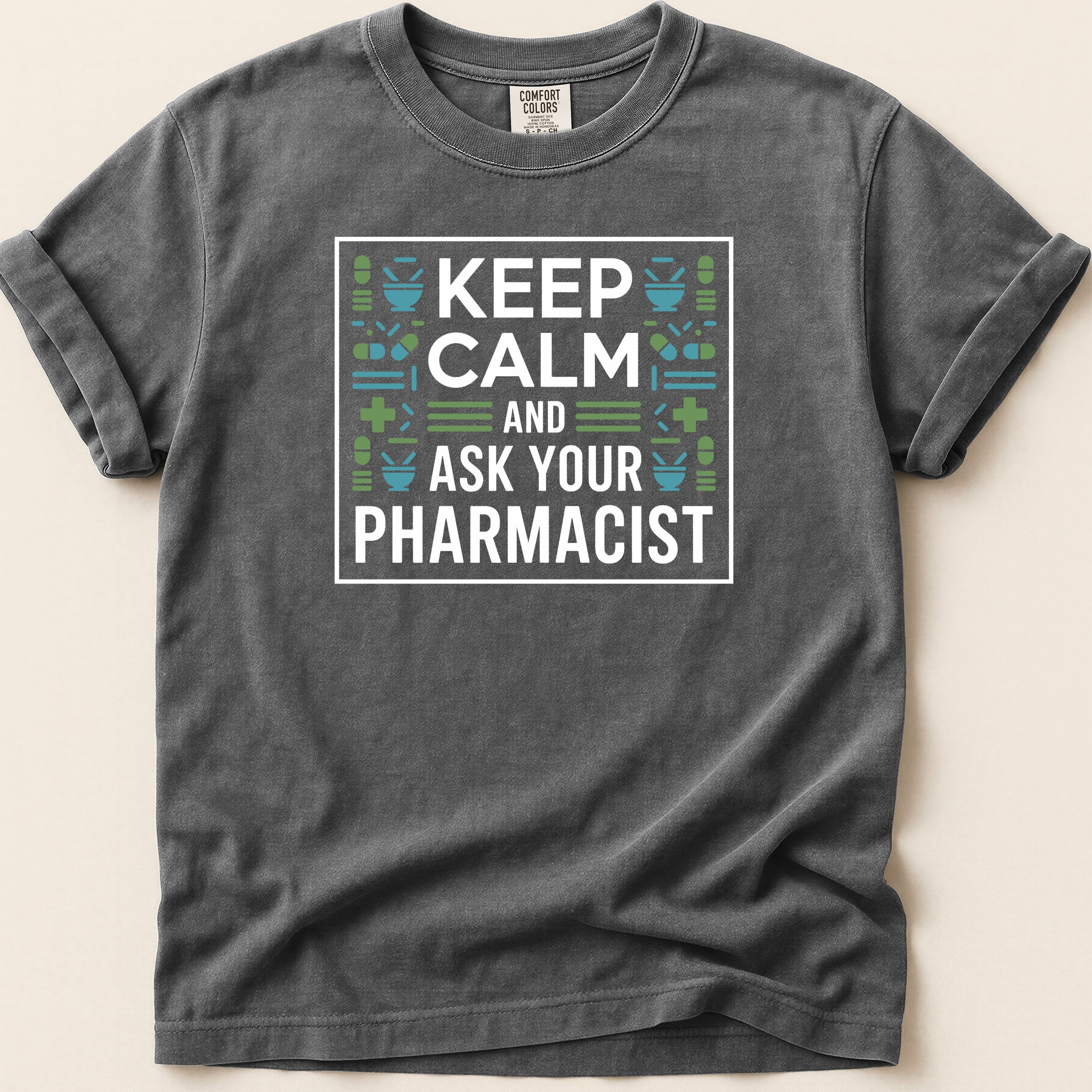 Dark grey t-shirt with "Keep Calm and Ask Your Pharmacist" text and medical icons.