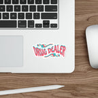 Sticker with wavy pink and blue text "DRUG DEALER" on a laptop.