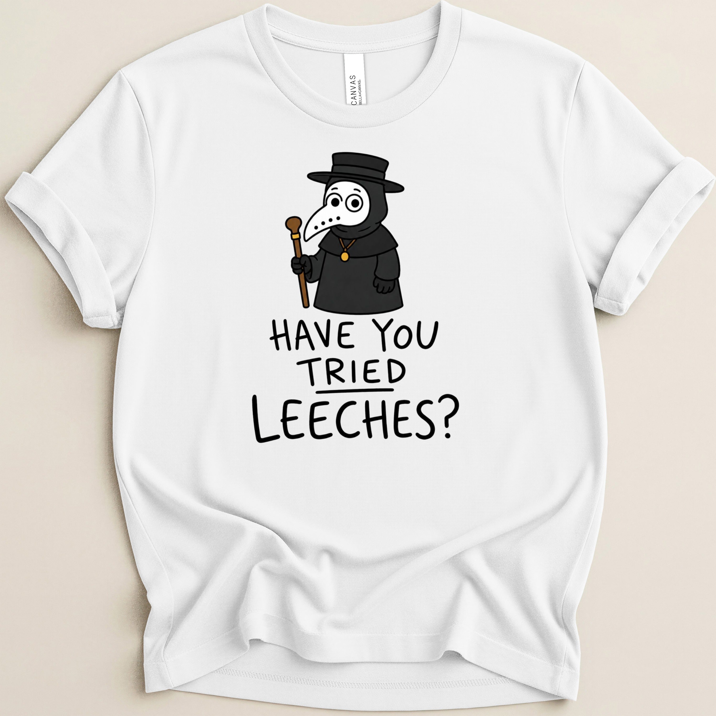 White t-shirt with cartoon plague doctor and text "HAVE YOU TRIED LEECHES?".