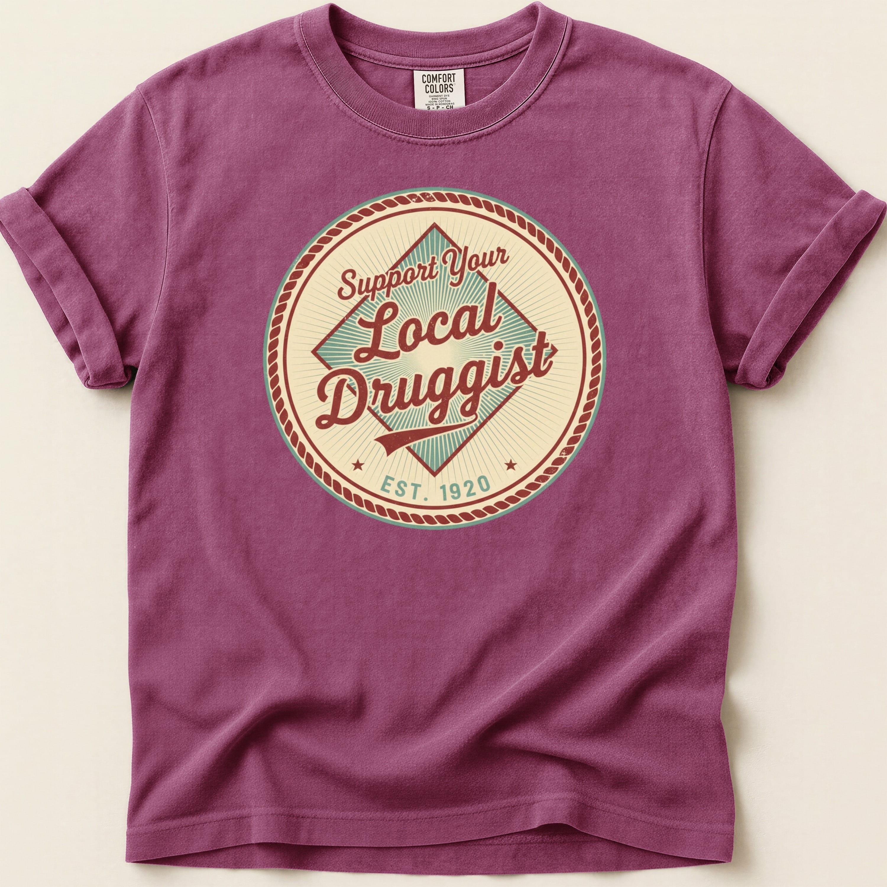 Purple t-shirt with "Support Your Local Druggist EST. 1920" circular graphic.