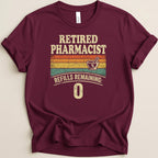 Maroon t-shirt with "Retired Pharmacist Refills Remaining: 0" text.