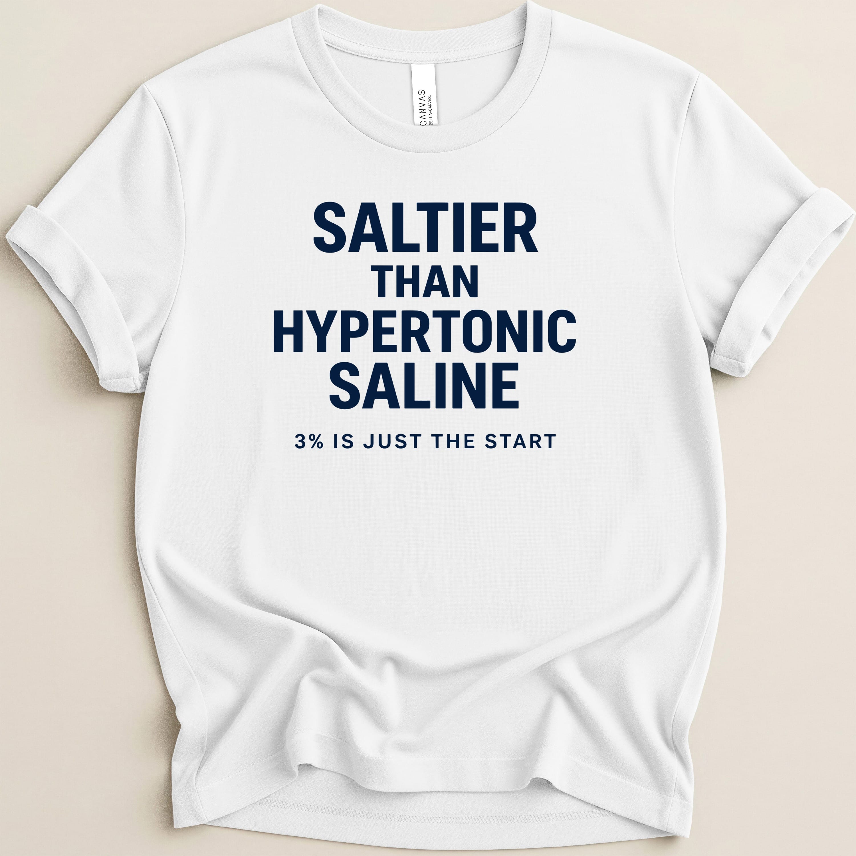 White t-shirt with navy text reading "SALTIER THAN HYPERTONIC SALINE 3% IS JUST THE START".