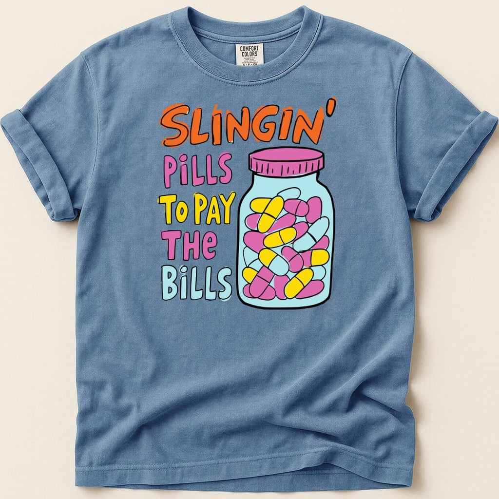 Blue t-shirt with "Slingin' Pills To Pay The Bills" text and a jar of pills.
