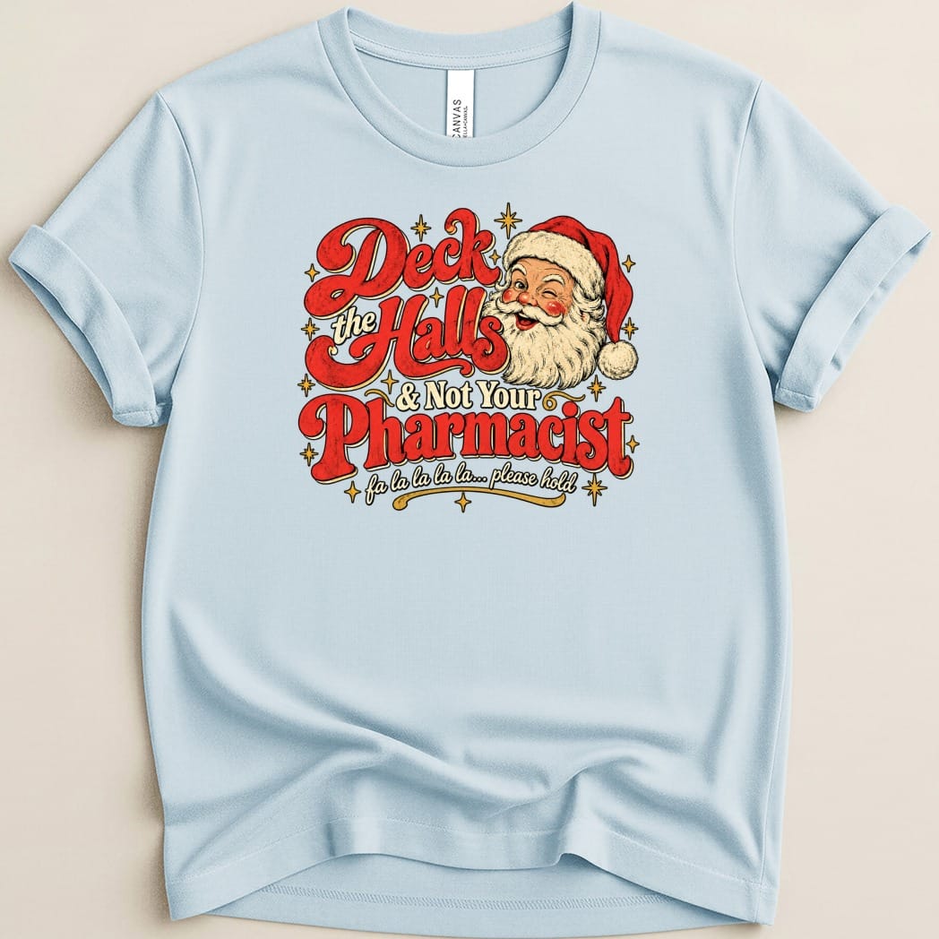 A light blue crewneck t-shirt featuring a retro graphic of a winking Santa and the text Deck the Halls & Not Your Pharmacist.