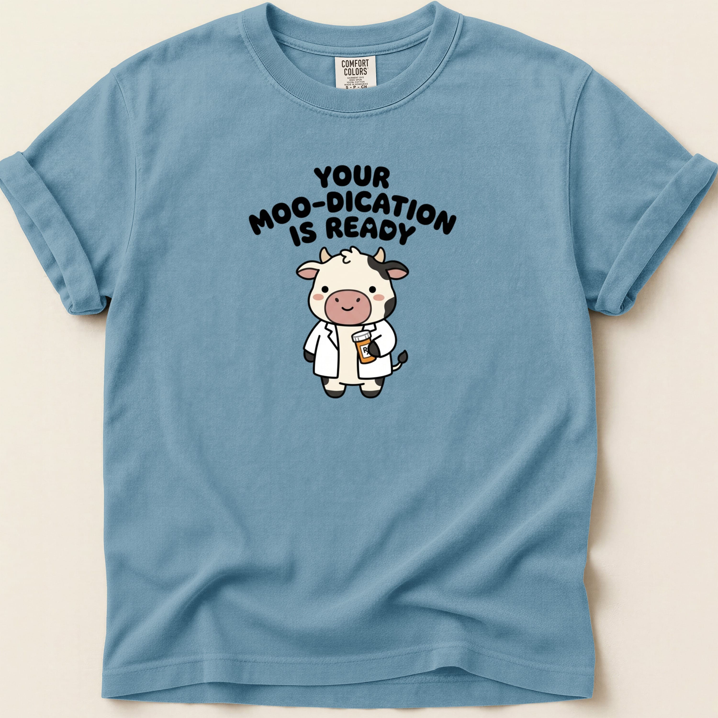 Blue t-shirt with cartoon cow and text "YOUR MOO-DICATION IS READY".