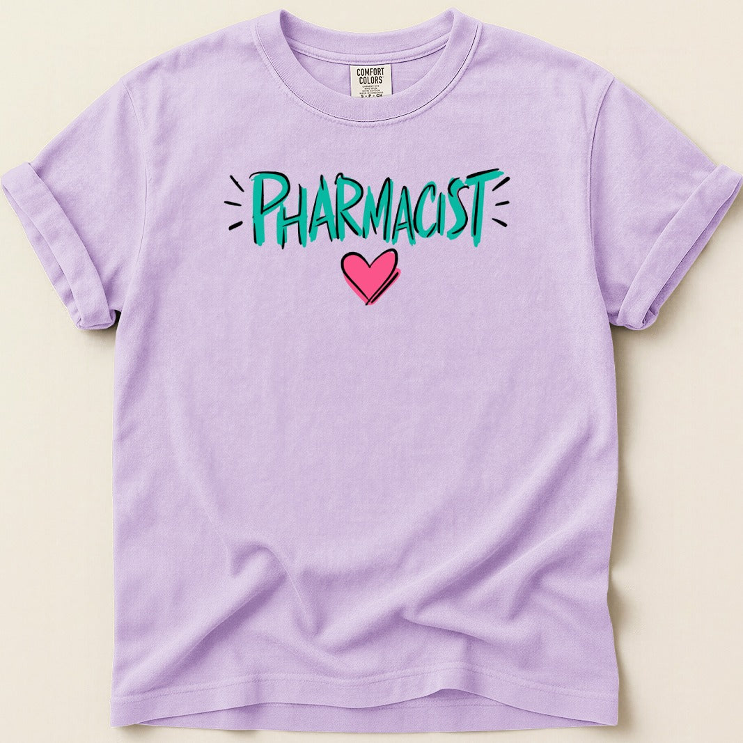 Purple Comfort Colors t-shirt with "PHARMACIST" text and pink heart graphic.