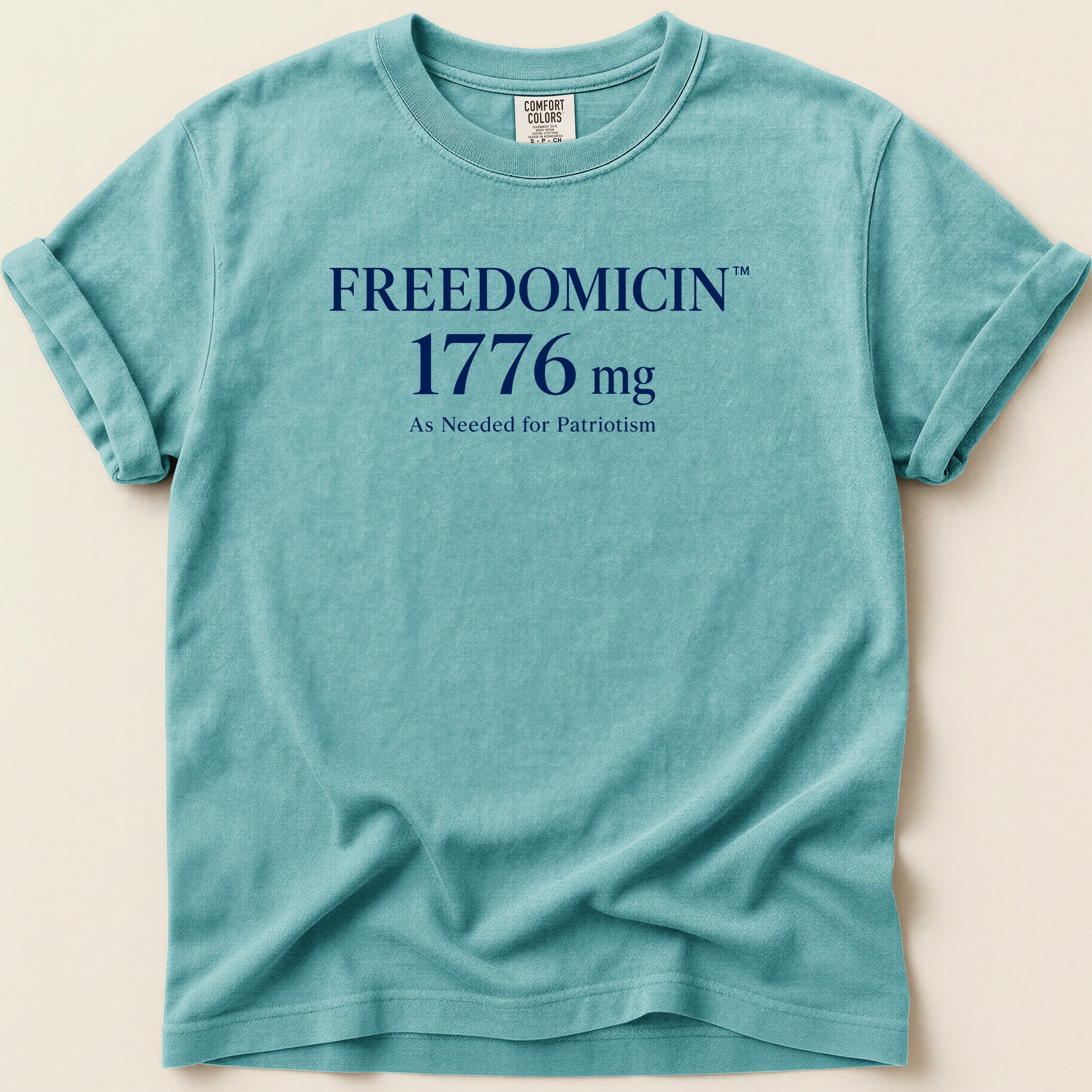 Teal t-shirt with "FREEDOMICIN 1776 mg As Needed for Patriotism" text.